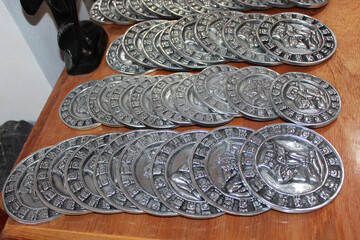Mexican souvenirs: silver coins with Mayan calendar in the souvenir shop in Chichen Itza, Riviera Maya, Quintana Roo, Mexico.