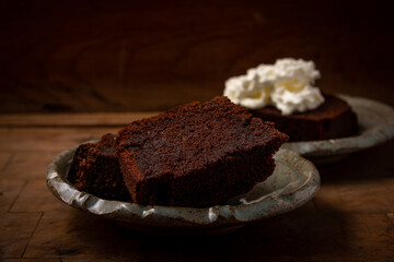 home made chocolate cake or browny with cream on wooden table ,unhealthy eating