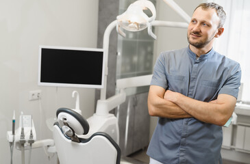 Fototapeta premium Portrait of a friendly male dentist in his office. Modern dental clinic.