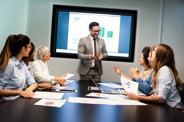 Group of business partners discussing documents and ideas at meeting