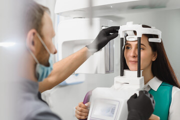 Young woman ready to computer 3d tomography of teeth and jaw in modern dental clinic