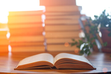 Book background. Blurred open book on a table in a university or school library in the sunlight...