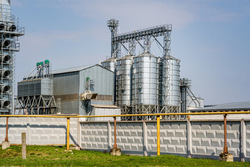 Modern Granary elevator. Silver silos on agro-processing and manufacturing plant for processing drying cleaning and storage of agricultural products, flour, cereals and grain. seed cleaning line