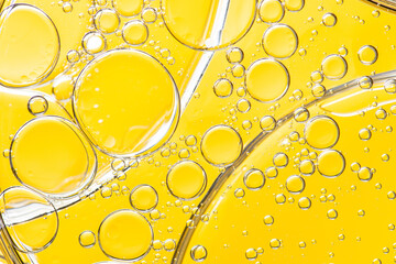 Beautiful macro photo of water droplets in oil with a yellow background. Abstract art