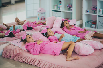 Three little girls lying on bed.