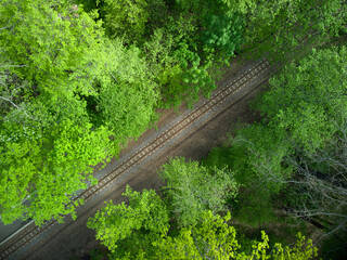 Aerial view of a train railroad in the green forest. children's narrow gauge railway