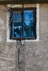 Old window on a wall with big crack