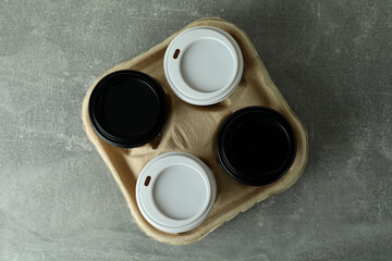 Obraz na płótnie Canvas Cup holder with coffee cups on gray textured background