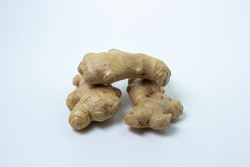 Ginger on a white background. Ginger root. Three whole ginger lie next to each other