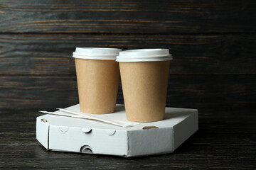 Pizza box and paper cups on wooden background