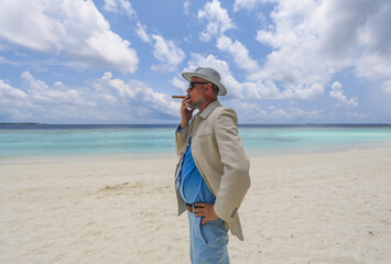 man with a cigar on a tropical island