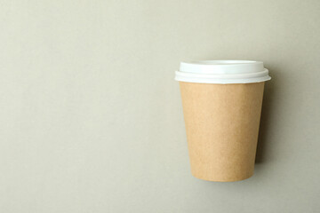 Blank paper cup on light gray background, space for text
