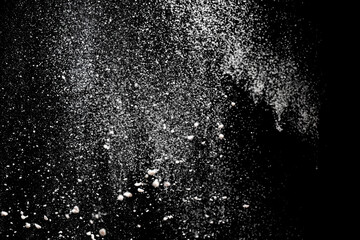 Fototapeta na wymiar White powder explosion. White powder splash isolated on black background. Flour sifting on a dark background. Explosive powder white