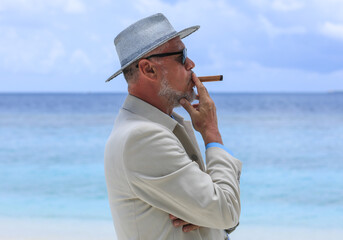man with a cigar on a tropical island
