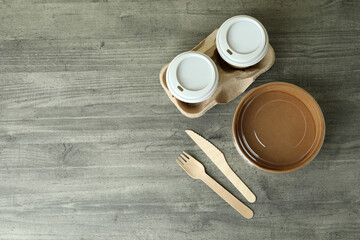 Delivery tableware on gray textured table, top view