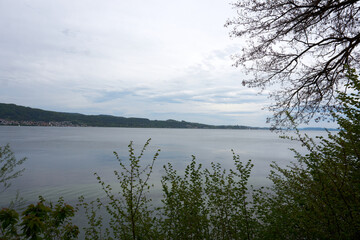 view of lake constance with clouds, mountains and trees