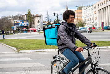 Male courier with bicycle delivering packages in city.