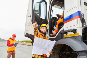 Foreman gives truck drivers an instruction