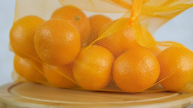 Oranges in eco bag. A view of a string eco bag with oranges on the table.