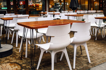 Wet tables and chairs in a modern summer cafe after the rain. Raindrops on the table. Veranda of the restaurant terrace bistro on the street