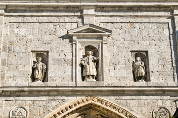 Obraz premium Detalle esculturas de tres santos, de izquierda a derecha, San Juan, San Antolín y San Almaquio, sobre la portada de la puerta de los reyes en la catedral de Palencia, España