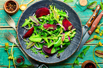 Spring greens and beetroot salad,wooden table