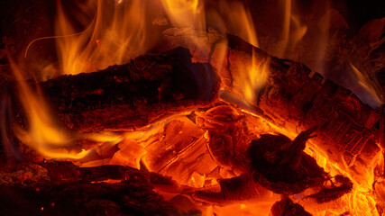 Close up view of the small fire and embers in a campfire or in a fireplace. - obrazy, fototapety, plakaty