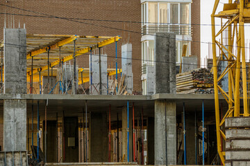 Work in progress on a new apartment block. Tall building under construction with cranes. Construction Site of New Building