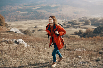 a traveler in a jacket jeans and boots climbs the mountains in nature landscape