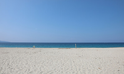 Fototapeta na wymiar beach made of white pebbles and a blue sea on a clear summer day