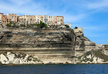 Fototapeta na wymiar Houses of Bonifacio City on the French island Corsica built over the sheer cliff seen from the Mediterranean Sea