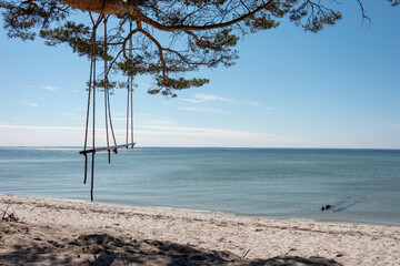 Vintage wooden swing on the beach. Shore of the Batlic Sea, Hel, Pomerania, Poland. Selective focus. 