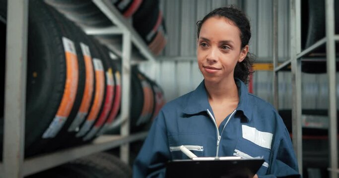 Women is checking the stock of car tires at the warehouse for tire inspection to check the balance of the product in auto repair shop store.Women is checking the stock of car tires at the warehouse fo