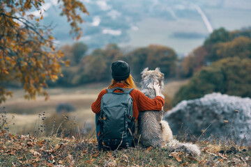 woman tourist next to a dog in the mountains travel landscape