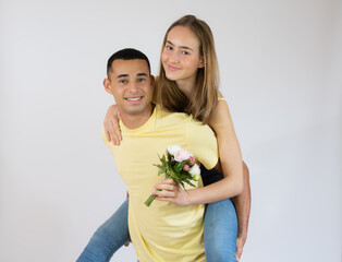 Cute young couple embracing and looking the camera over white background