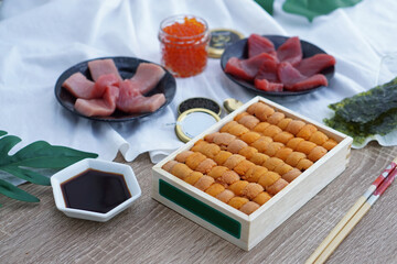 A box of uni sashimi on table served with soy sauce, Fresh sea urchin roe.