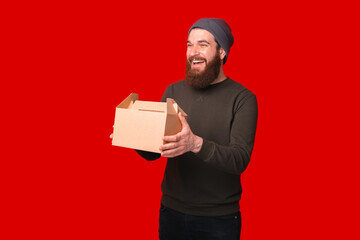 Photo of smiling young man with beard holding lunch box