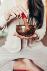 Relaxed woman meditating with singing bowl