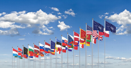 The 30 waving Flags of NATO Countries - North Atlantic Treaty. Isolated on sky background  - 3D illustration. - obrazy, fototapety, plakaty