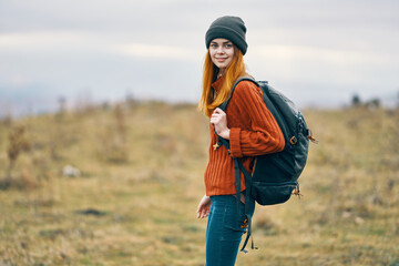 Naklejka na ściany i meble woman hiker with backpack in the mountains fresh air travel nature