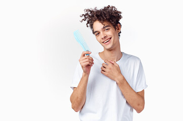 cheerful man in a white t-shirt comb hair curls emotions