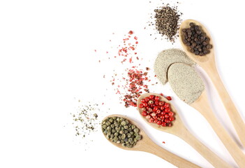 Ground peppercorn mix, white, black, green and red pepper piles in wooden spoons isolated on white...