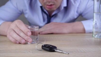 A Man Sitting  with Car Keys on the Table Drinking Alcohol. Alcohol abuse, drunk driving and people concept