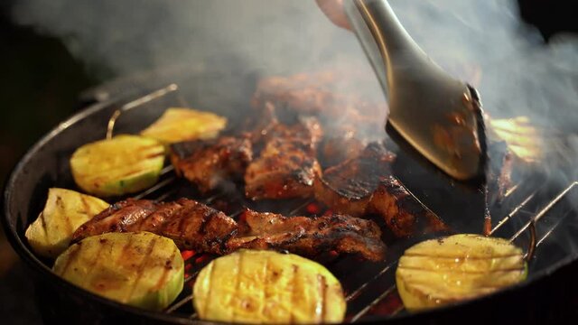 cooking tongs turn vegetables. cooking mouth-watering ribs and grilled vegetables