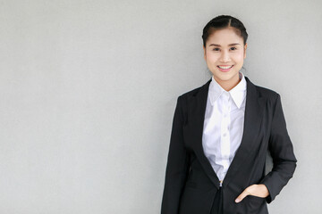 Portrait closeup shot of Asian female smart successful female businesswoman with braid hairstyle wears formal black suit with white shirt stand smiling look at camera put hand in jacket pocket