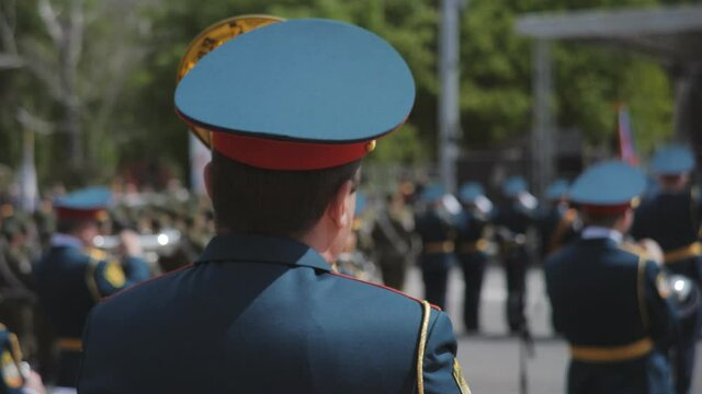 A wind instrument military parade - soldiers standing on the street and playing instruments