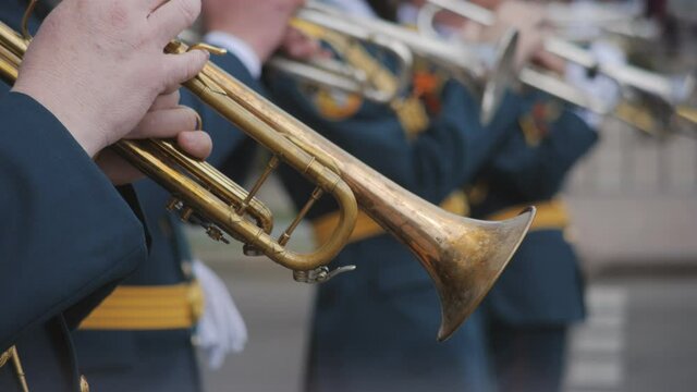 Close-up of wind instruments. A military band plays brass instruments at a military parade or city festival. Brush tool.