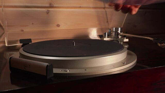 on a turntable, male hands move the turntable head away, lift the blue record and turn it over