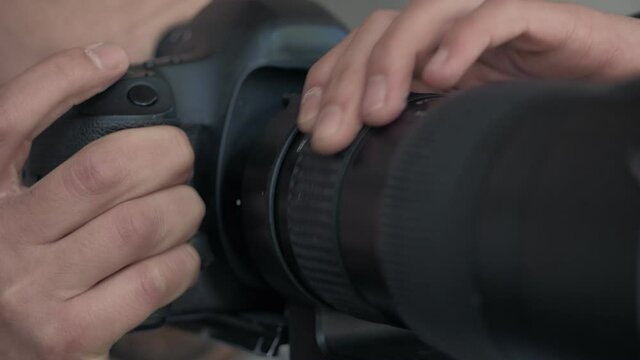 A man takes photos using a SLR camera with a large lens.