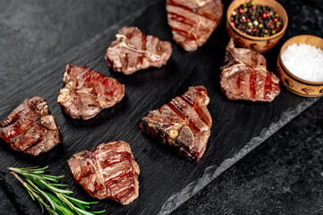 several mini Grilled beef T-bone steaks on stone background